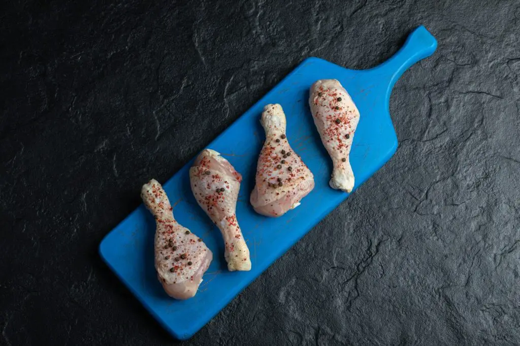 top view raw chicken drumstick blue wooden board 114579 48870 1024x683 1