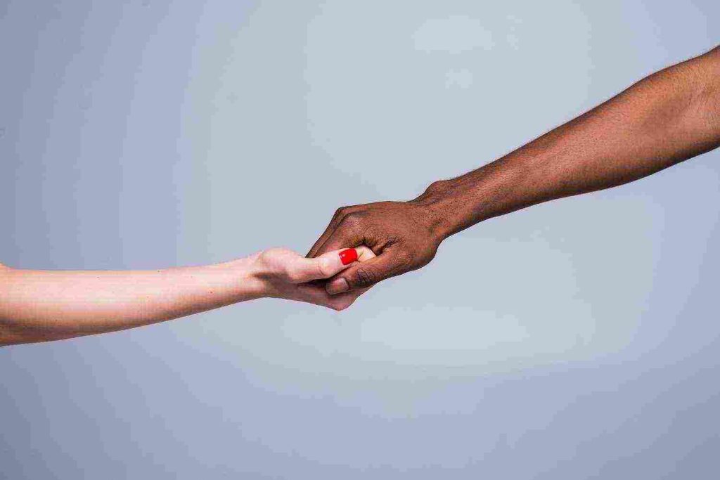 white caucasian female hand black male hand holding fingers together 1024x683 1