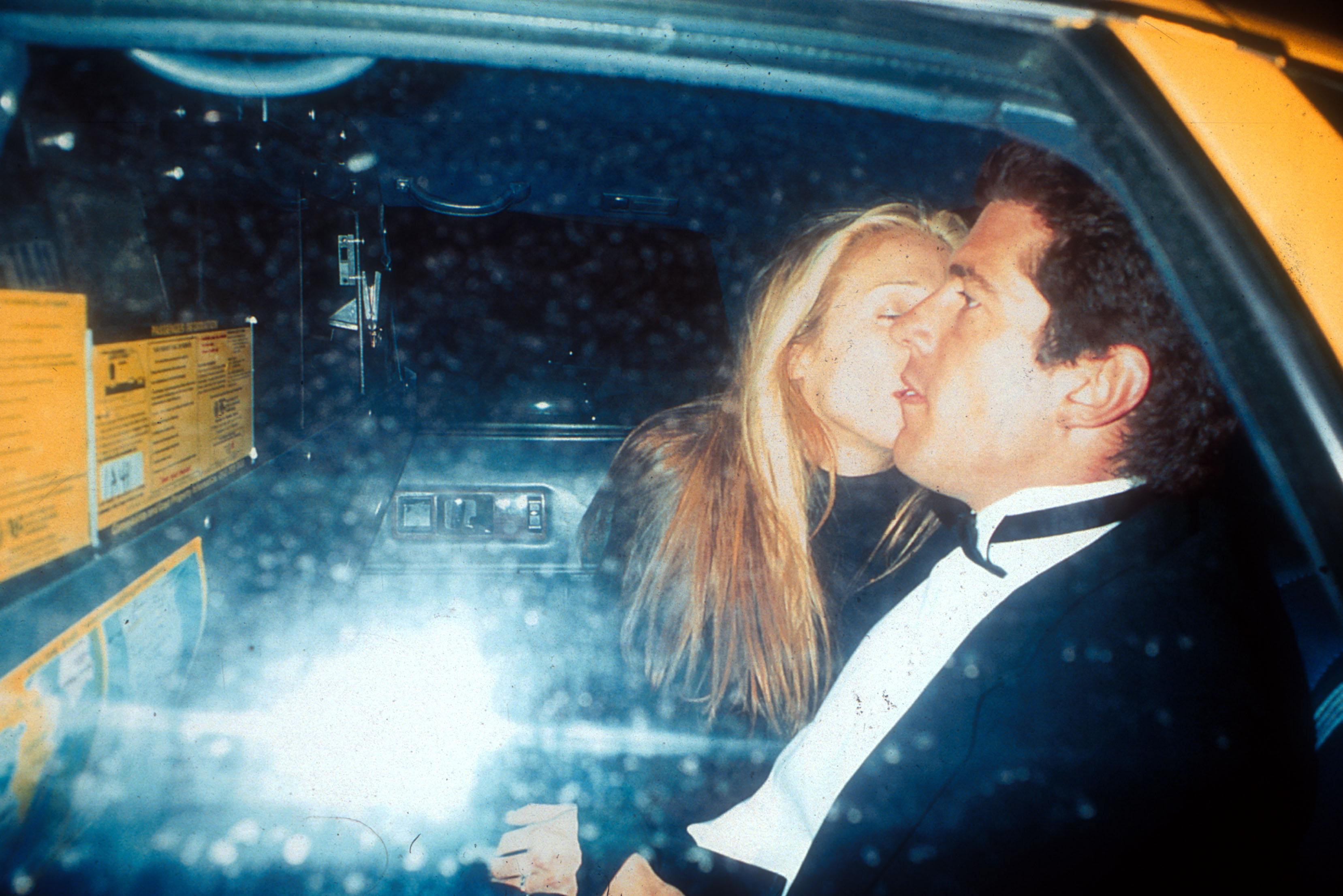 Carolyn Bessette-Kennedy photographed planting a kiss on John F. Kennedy Jr.'s cheek in the back of a taxi in New York on March 11, 1996. | Source: Getty Images