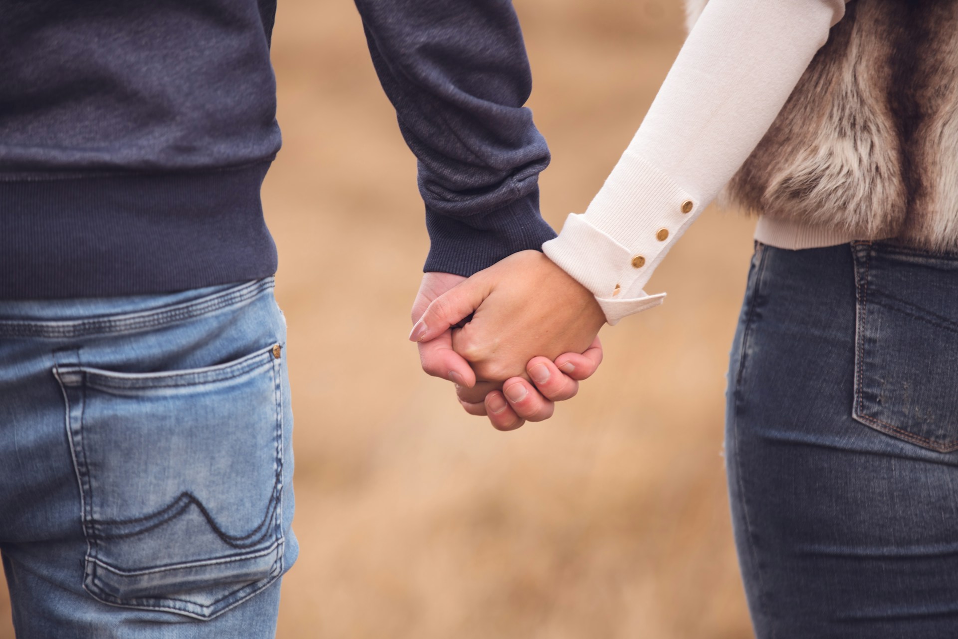 Cropped shot of a couple holding hands | Source: Unsplash