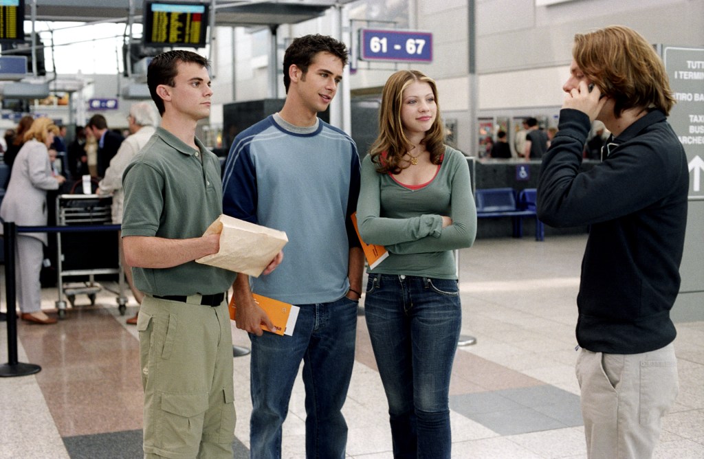 Travis Wester, Scott Mechlowicz, Michelle Trachtenberg, and Jacob Pitts in a scene from the movie Eurotrip, standing in a terminal.